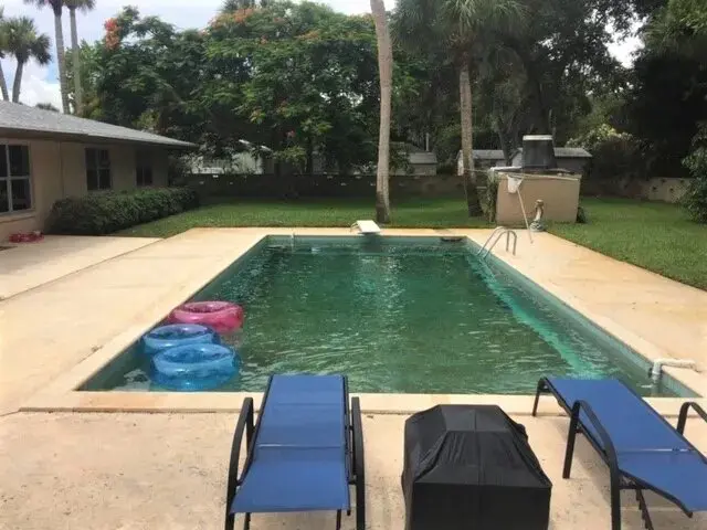 A pool with chairs and an empty swimming pool.