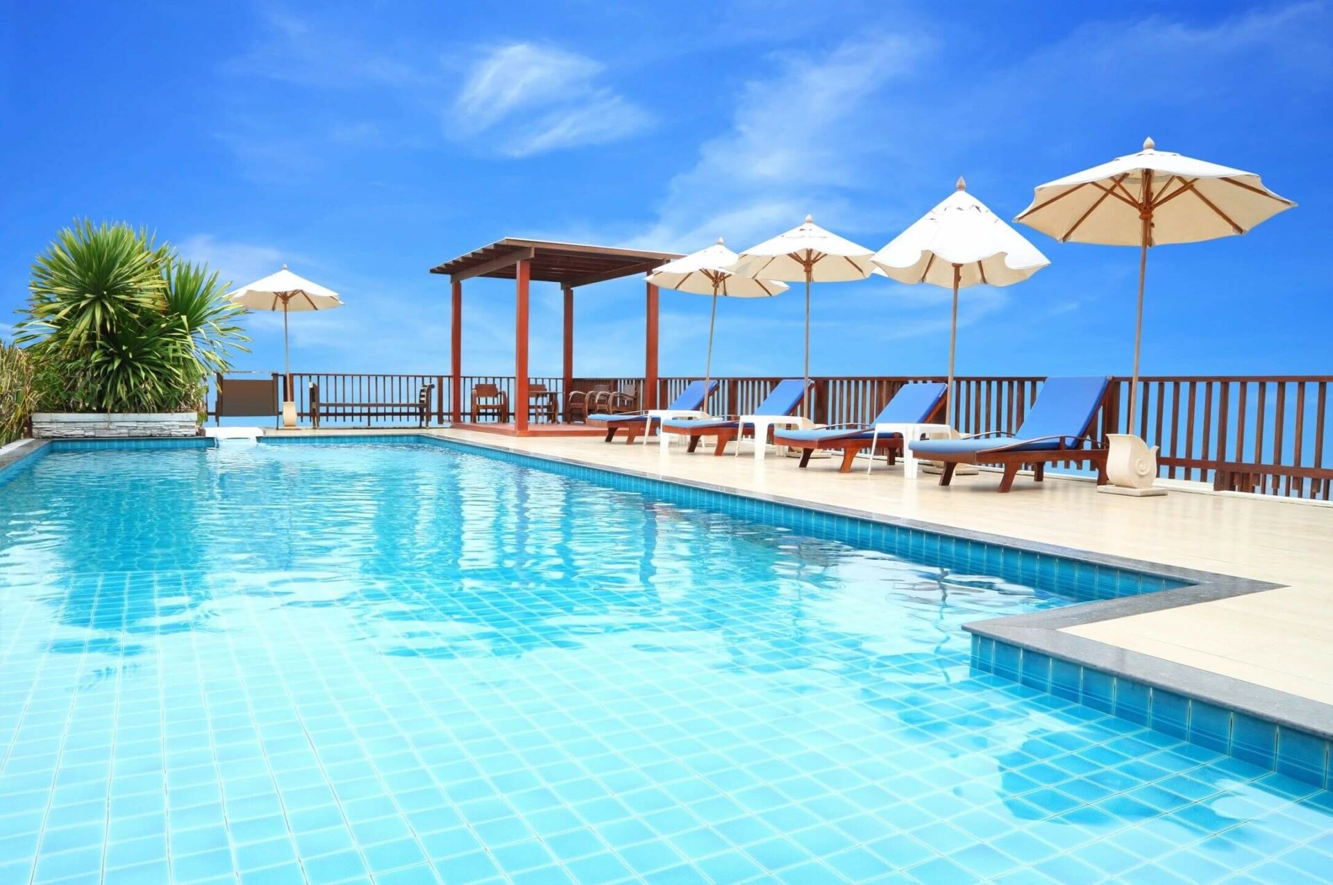 A pool with chairs and umbrellas next to it